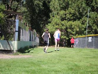 Cross country boys running towards trees