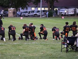 football players taking a knee