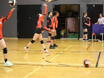 Varsity Volleyball player serving the ball