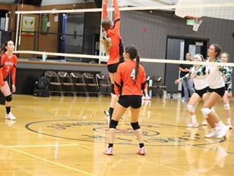 Varsity Volleyball blocking the ball